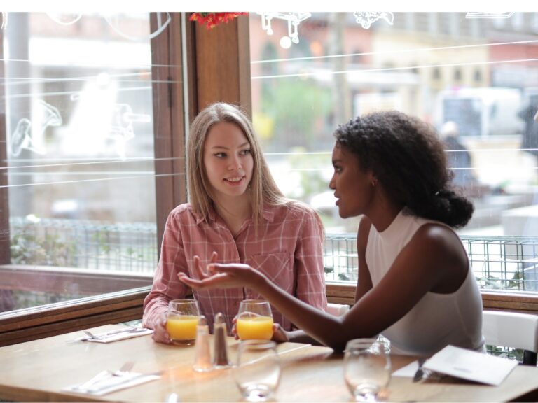 Auf dem Bild sieht man zwei Frauen, welche sich in einem Restaurant über Nahrungsmittelintoleranzen unterhalten.