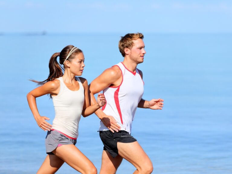 Zwei Menschen die am Strand joggen. Trotz einer Histaminunverträglichkeit machen sie ganz normal Sport.