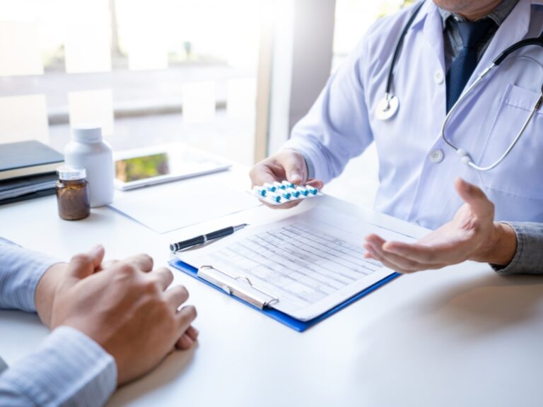 Ein Doktor übergibt ein Medikament an einen Patienten. Histaminintoleranze Personen müssen hierbei auf potenzielle Auswirkungen auf ihre Intoleranz achten.
