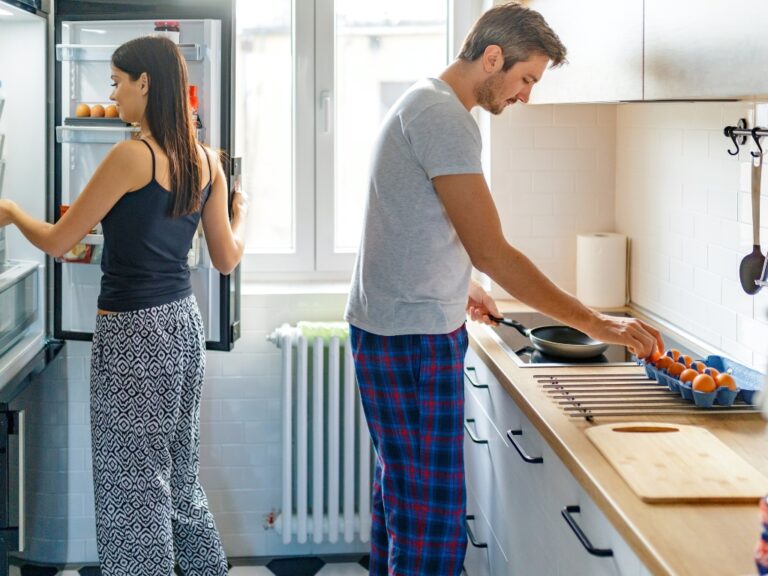 Ein Pärchen steht in der Küche und bereitet Frühstück vor. Nach dem Urlaub ist es gerade für Menschen mit Intoleranzen wichtig, entspannt in den Alltag zurückzufinden.
